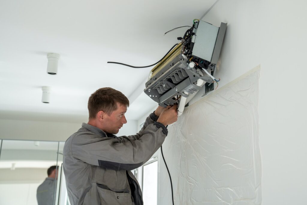 Man technician repairing apartment air conditioner
